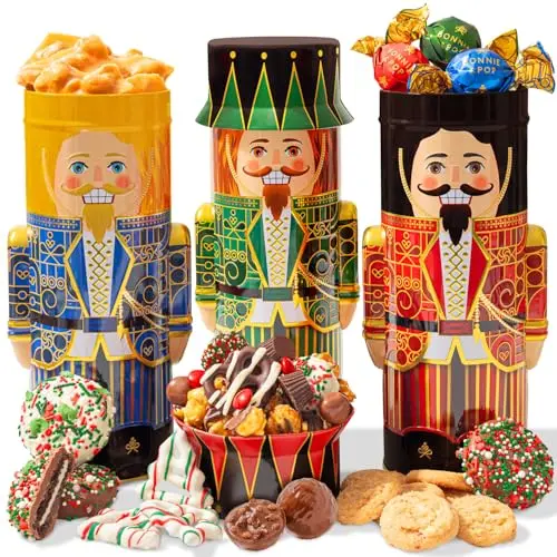 A festive holiday gift box containing three decorative toy soldier tins filled with an assortment of chocolates, cookies, and snacks.