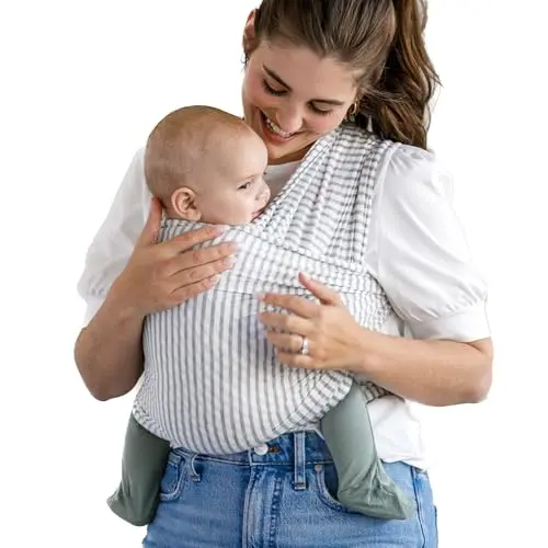 Solly Baby Wrap in Natural and Grey Stripe pattern, wrapped around a person holding a baby.