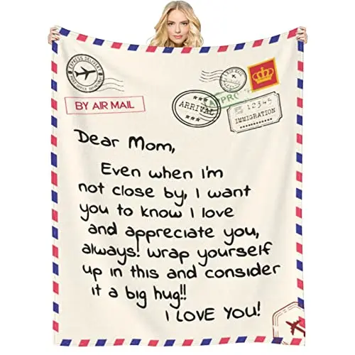 Light grey flannel throw blanket with 'Dear Mom' text folded on a couch
