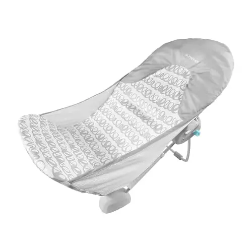 INGENUITY Foldaway baby bather with gray swirl pattern, folded flat next to a bathtub