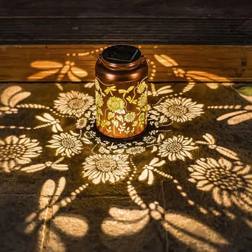 Metal solar lantern with sunflower cut-out design, hanging in a garden